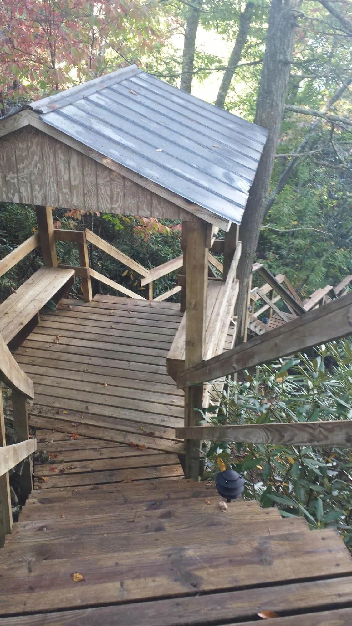 Metal roofed shelter over wooden steps on a wooded walkway — Skylight Repair & Installation work by our crew in Potsdam